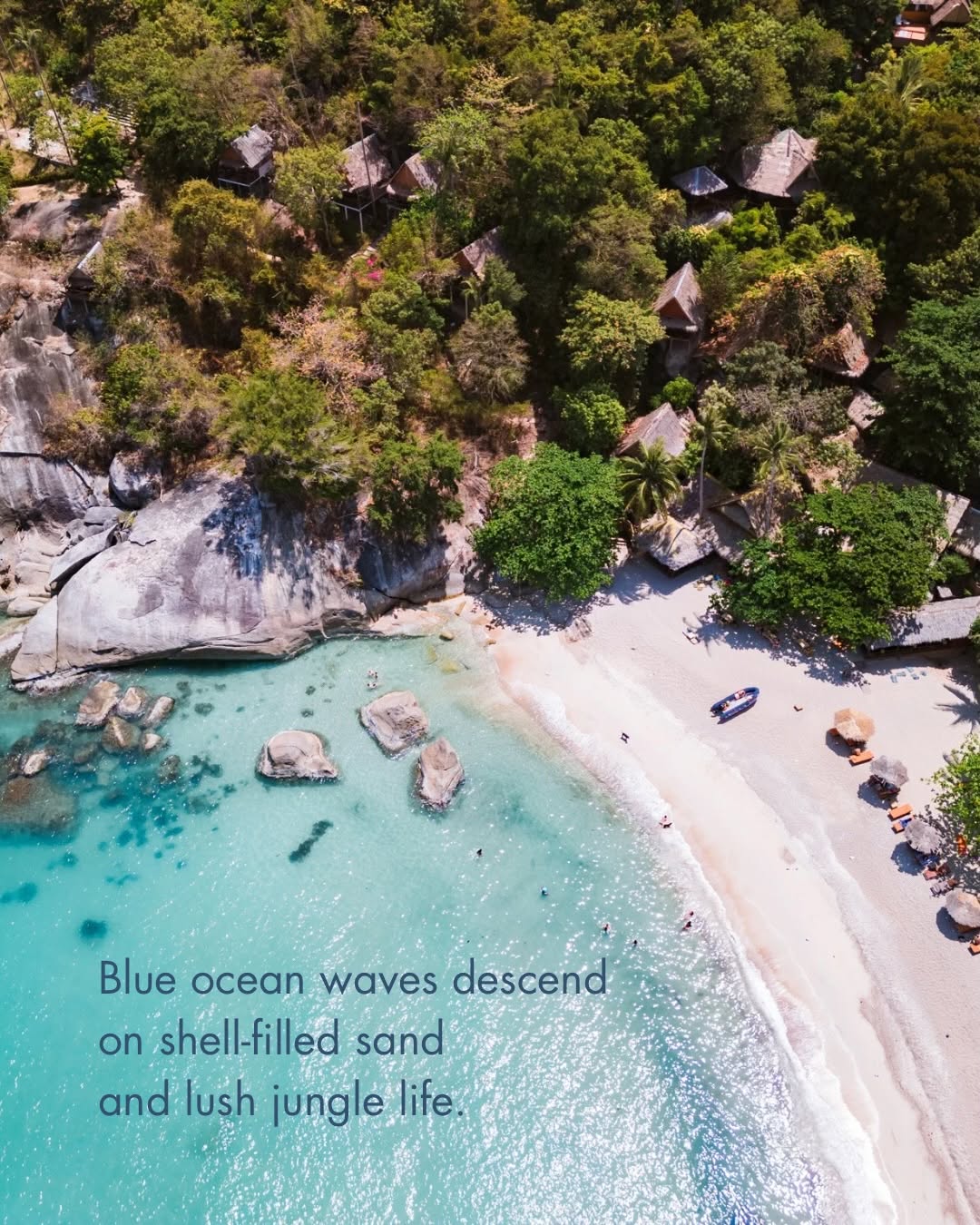 Aerial view of the retreat beach with turquoise water, white sand and jungle bungalows