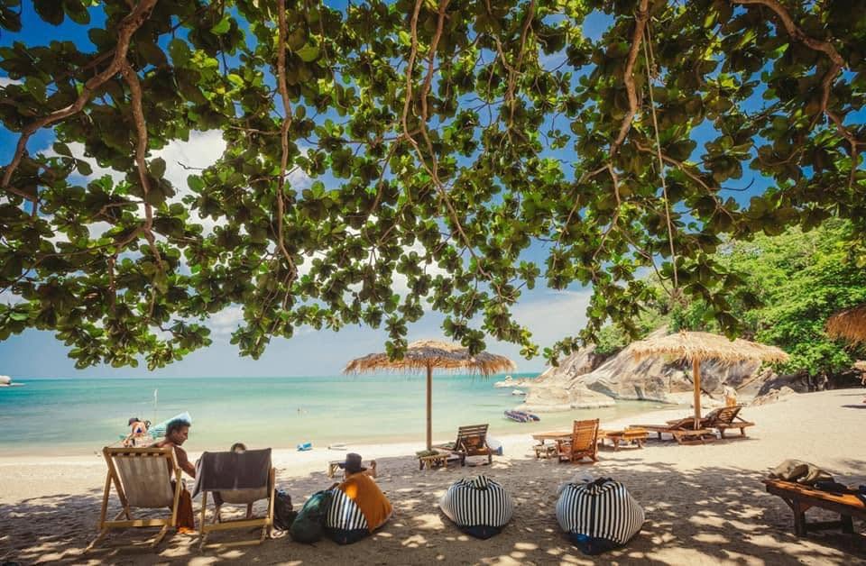 Shaded beach area with beanbags, loungers and thatched umbrellas overlooking the ocean